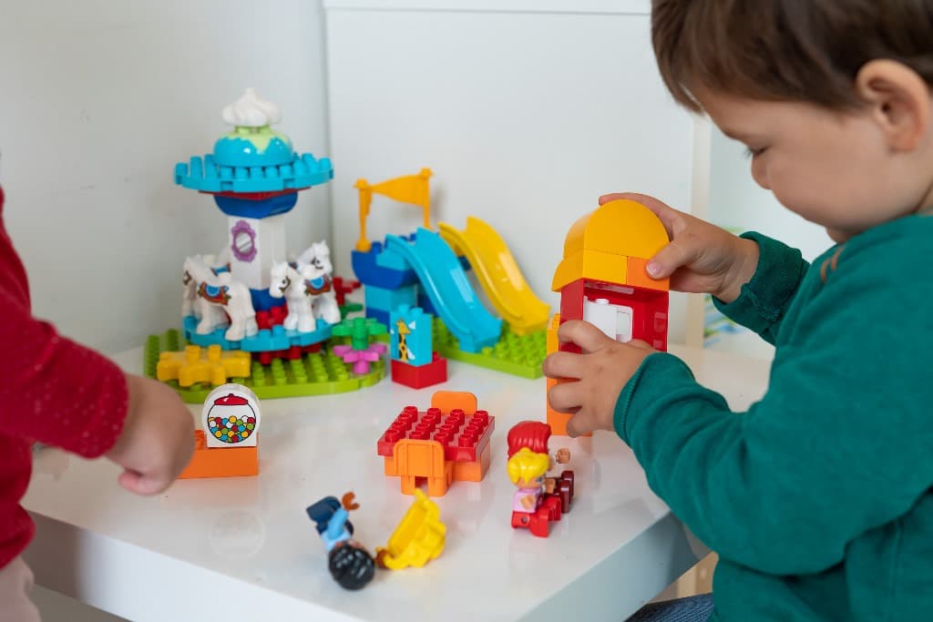Twee kinderen bouwen samen met Duplo aan tafel
