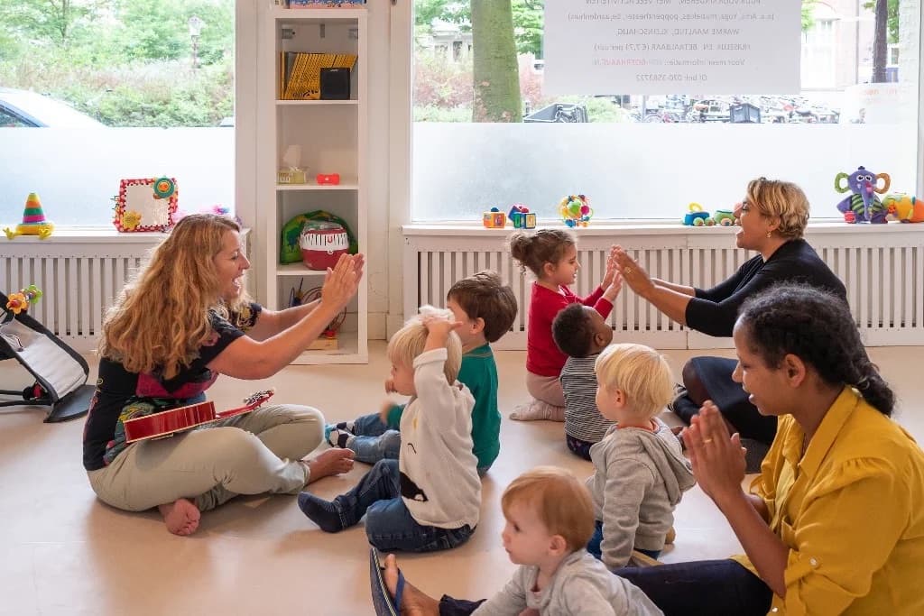 Pedagogisch professionals spelen samen met de kinderen in de groepsruimte