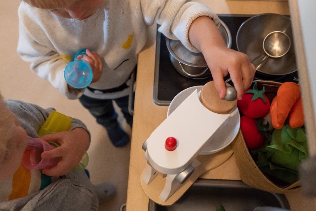 Twee kinderen spelen samen bij de speelkeuken